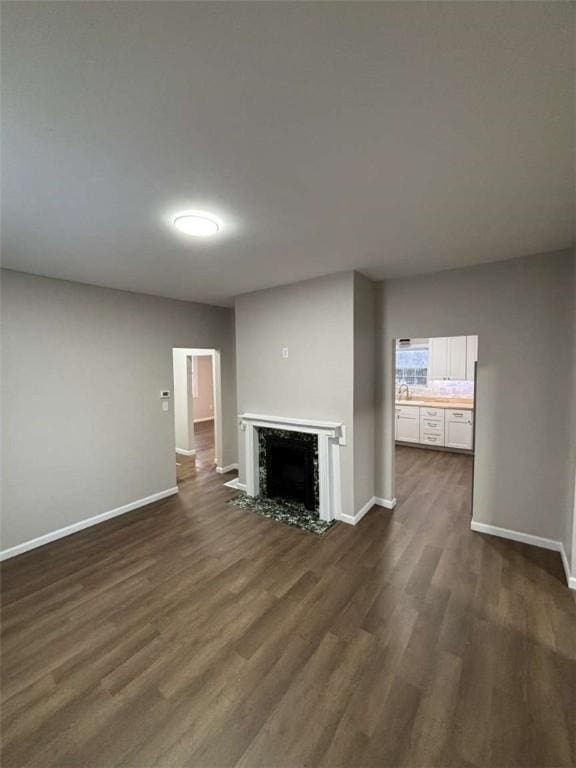 unfurnished living room with a premium fireplace and dark hardwood / wood-style floors