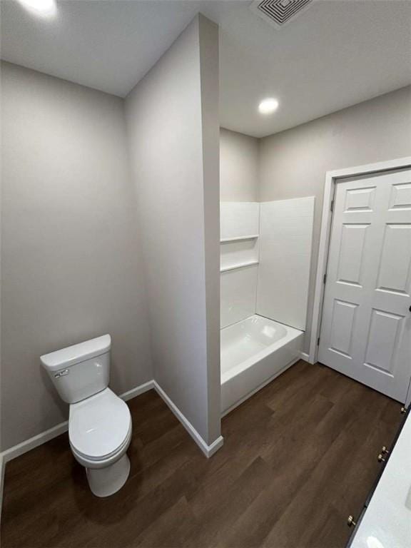 bathroom featuring a shower, hardwood / wood-style floors, and toilet