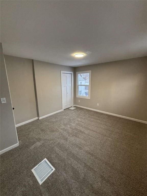 empty room featuring dark carpet