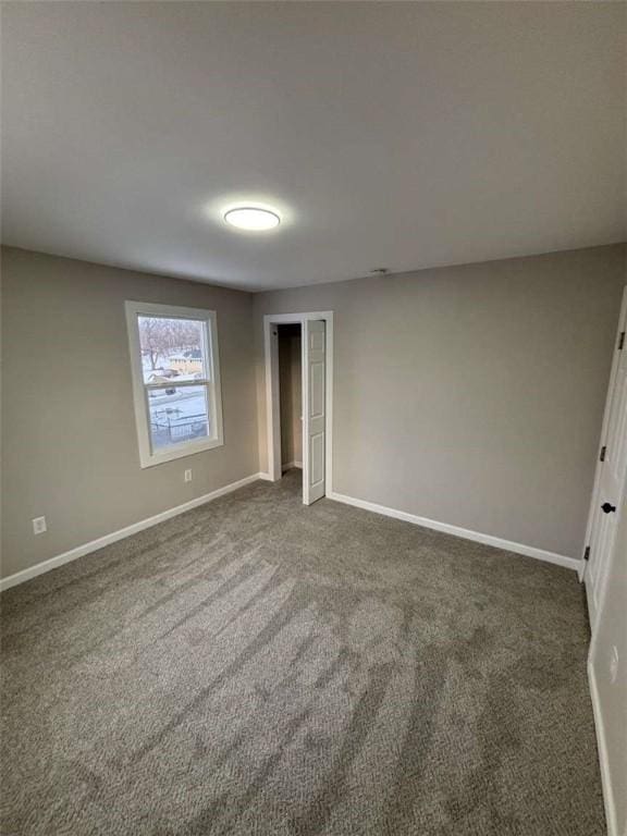 empty room featuring dark colored carpet