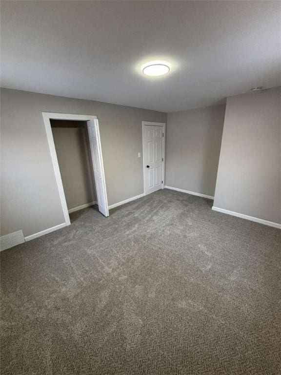 unfurnished room featuring dark carpet