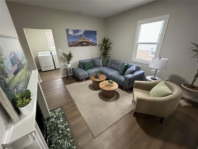 living room with dark wood-type flooring and washing machine and dryer