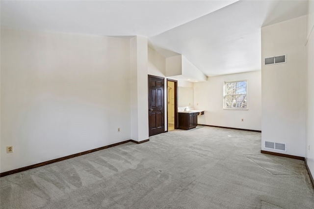 carpeted empty room featuring lofted ceiling