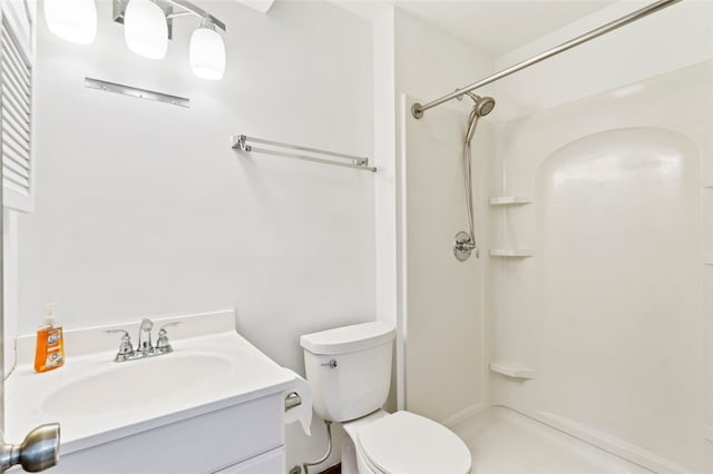 bathroom featuring vanity, toilet, and a shower