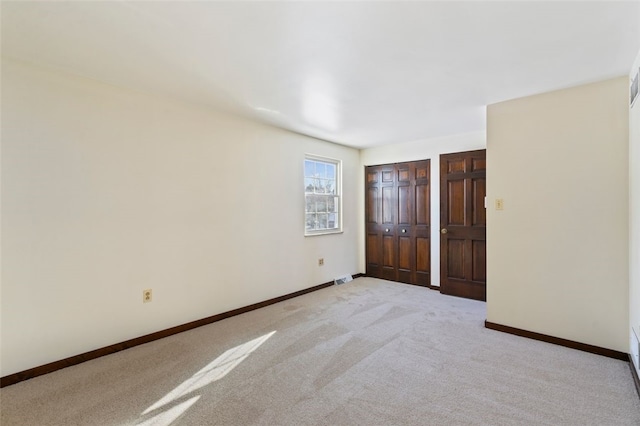 unfurnished bedroom with light carpet and a closet