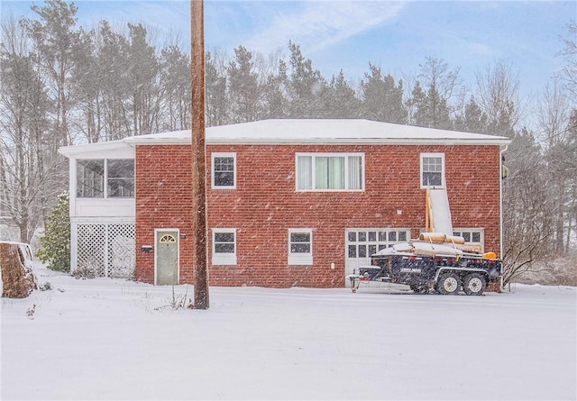 snow covered property with a garage