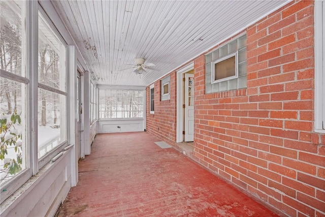 unfurnished sunroom featuring wooden ceiling and ceiling fan