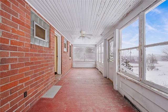 unfurnished sunroom with ceiling fan