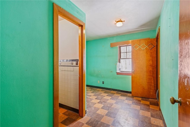 hall featuring tile walls