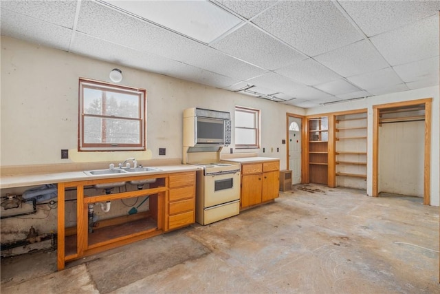 kitchen featuring a drop ceiling, sink, and white range with electric cooktop