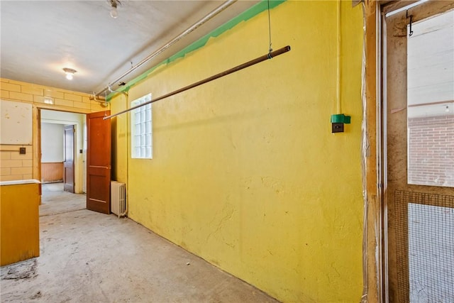 corridor featuring radiator heating unit and concrete floors