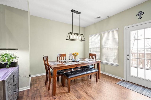 dining space with plenty of natural light and hardwood / wood-style floors