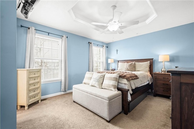 bedroom with light carpet, a raised ceiling, and ceiling fan