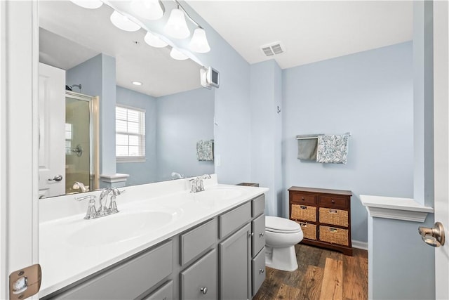 bathroom featuring an enclosed shower, vanity, hardwood / wood-style flooring, and toilet