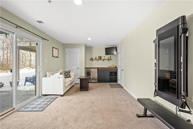 carpeted living room featuring wine cooler