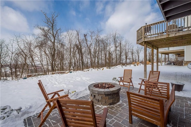 yard covered in snow featuring a deck and an outdoor fire pit