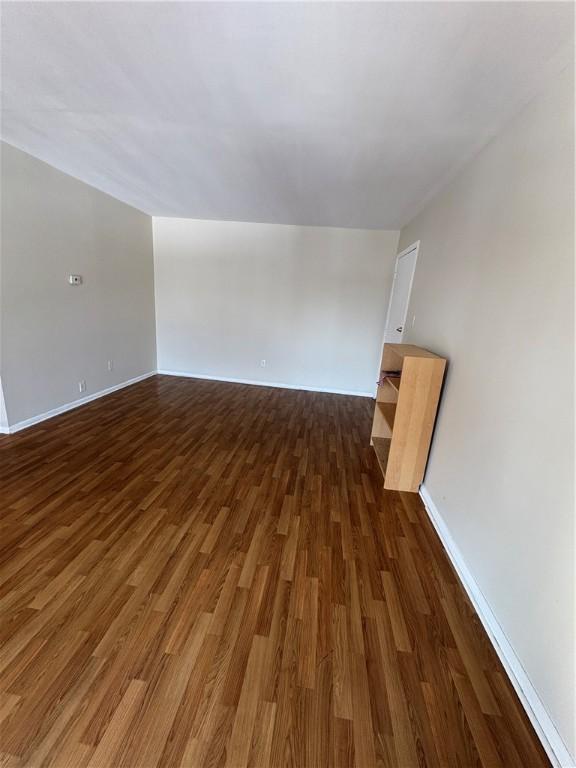 empty room with dark wood-type flooring