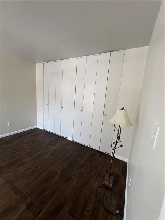 unfurnished bedroom featuring dark hardwood / wood-style flooring and a closet