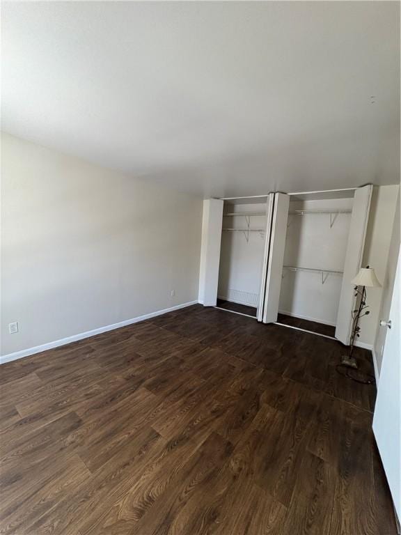 unfurnished bedroom featuring dark wood-type flooring and a closet