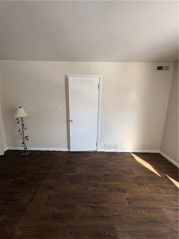 unfurnished room with dark hardwood / wood-style flooring