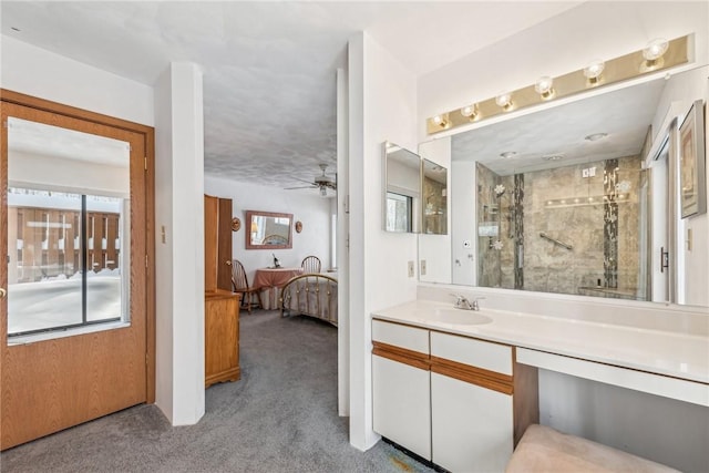 bathroom featuring a shower, vanity, and ceiling fan