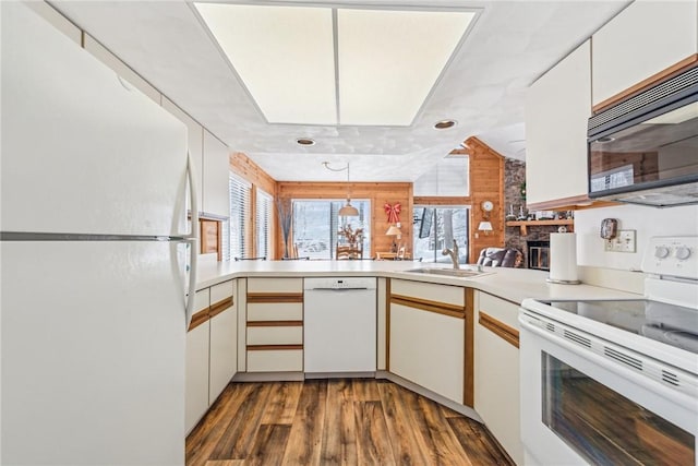 kitchen featuring white cabinetry, sink, white appliances, and kitchen peninsula