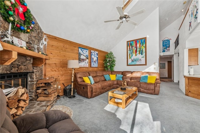 living room with a fireplace, light colored carpet, wooden walls, and high vaulted ceiling