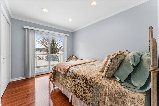 bedroom with access to exterior, hardwood / wood-style flooring, ornamental molding, and a closet