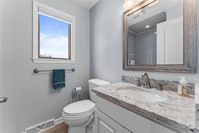 bathroom with vanity, toilet, and hardwood / wood-style floors