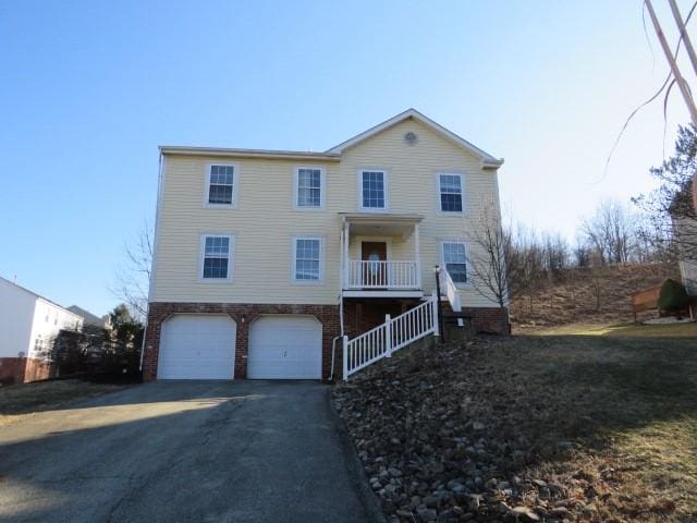 view of front of house with a garage, driveway, and brick siding