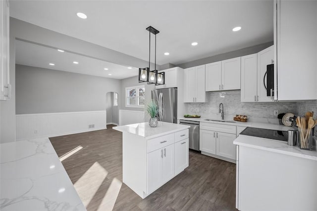 kitchen featuring white cabinetry, sink, hanging light fixtures, a center island, and stainless steel appliances