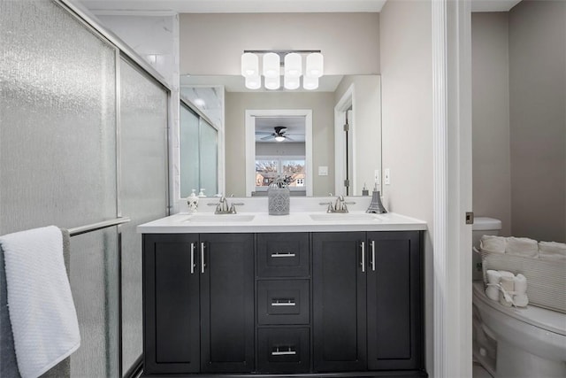 bathroom with vanity, a shower with shower door, ceiling fan, and toilet