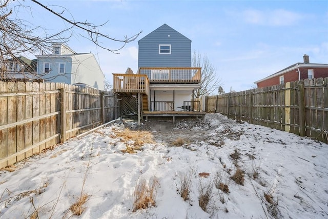 snow covered rear of property featuring a wooden deck