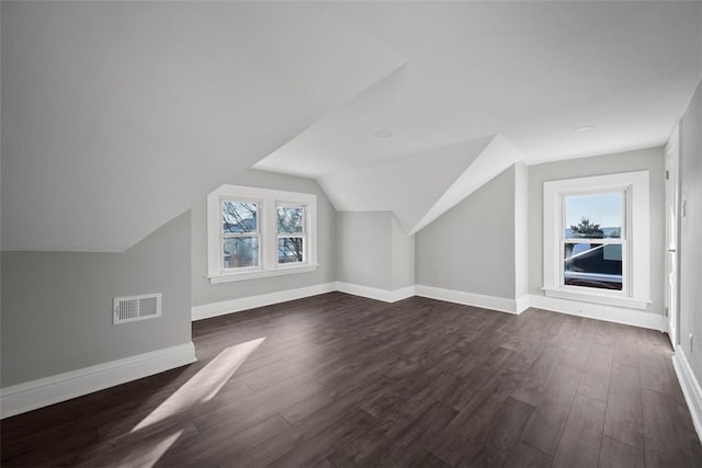 bonus room with vaulted ceiling, dark hardwood / wood-style floors, and a healthy amount of sunlight