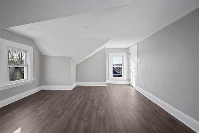 additional living space with lofted ceiling and dark hardwood / wood-style flooring