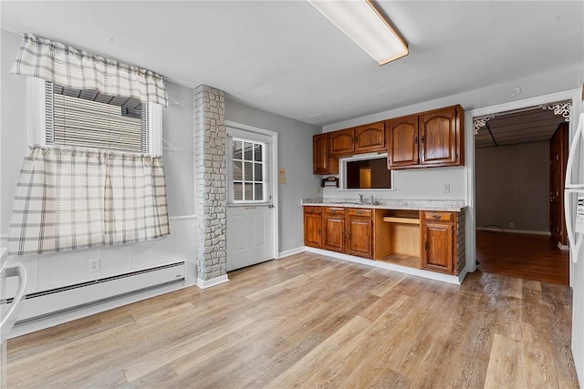 kitchen featuring a baseboard heating unit, light hardwood / wood-style flooring, and sink