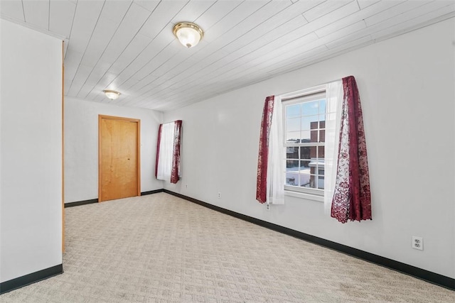 empty room featuring wood ceiling and light colored carpet