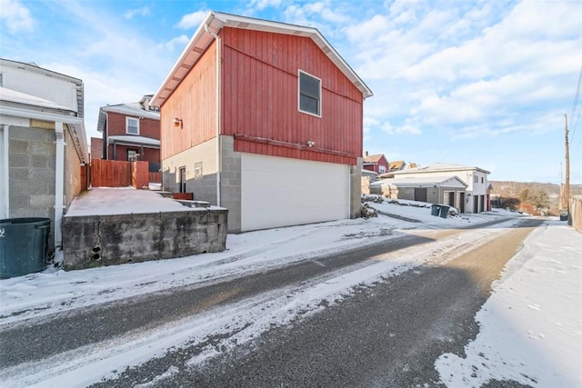 snow covered property with a garage