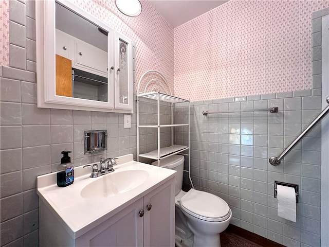 bathroom featuring tile walls, vanity, and toilet