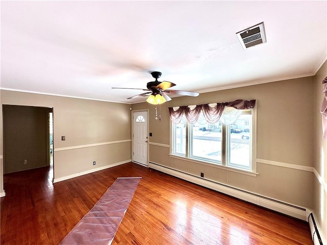 unfurnished room with crown molding, ceiling fan, wood-type flooring, and a baseboard heating unit