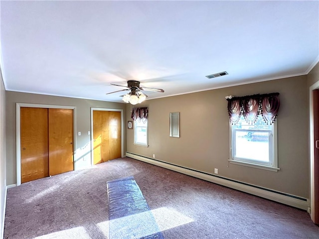 unfurnished bedroom featuring multiple windows, multiple closets, ceiling fan, and baseboard heating