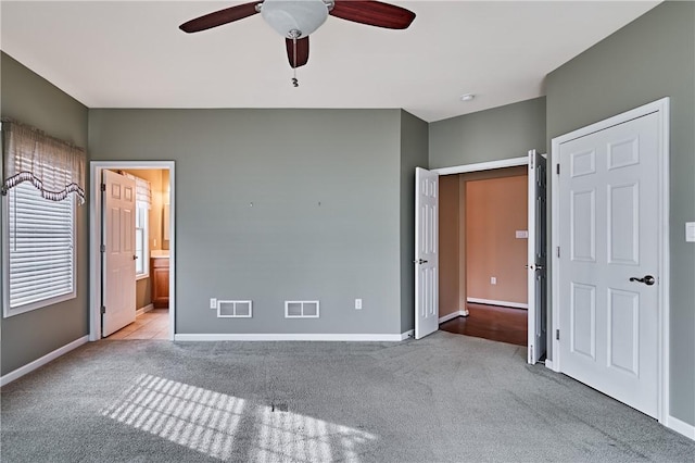 unfurnished bedroom featuring ceiling fan, connected bathroom, and light colored carpet