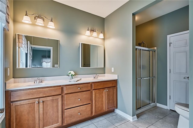 bathroom with toilet, vanity, a shower with door, and tile patterned flooring