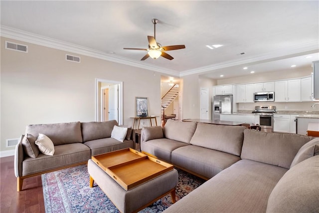 living room featuring ceiling fan, ornamental molding, and dark hardwood / wood-style floors