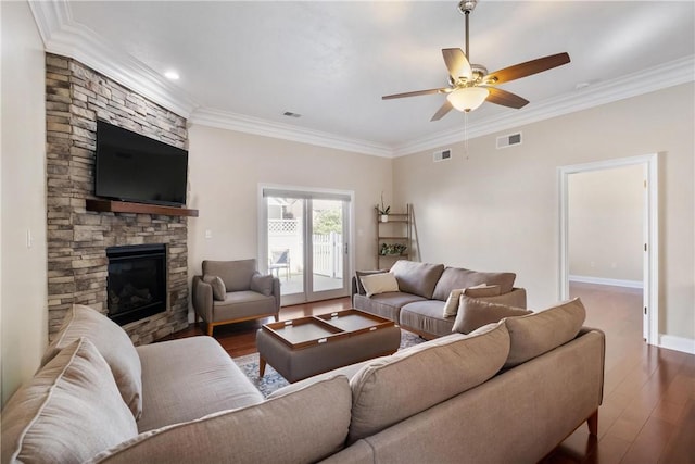 living room with ornamental molding, dark hardwood / wood-style floors, ceiling fan, and a fireplace