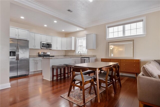 dining space featuring ornamental molding and dark hardwood / wood-style flooring