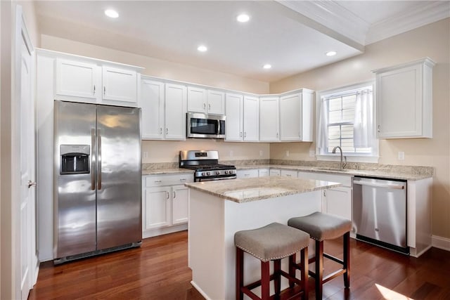 kitchen with white cabinetry, appliances with stainless steel finishes, dark hardwood / wood-style flooring, and a kitchen island