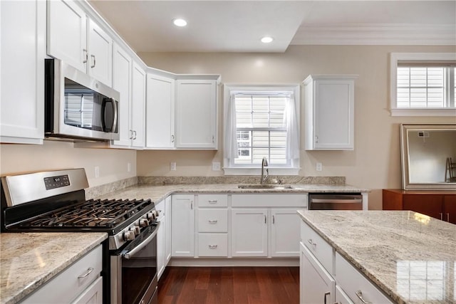 kitchen featuring white cabinetry, appliances with stainless steel finishes, light stone countertops, and sink