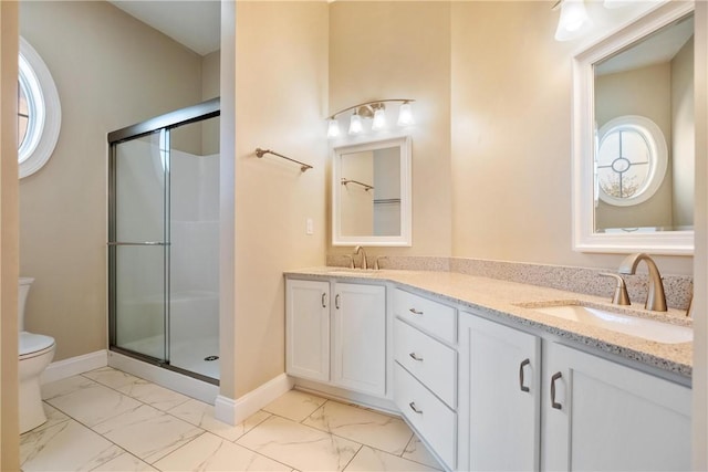 bathroom featuring vanity, a shower with shower door, and a healthy amount of sunlight