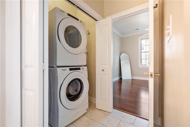 laundry area with ornamental molding and stacked washer / dryer